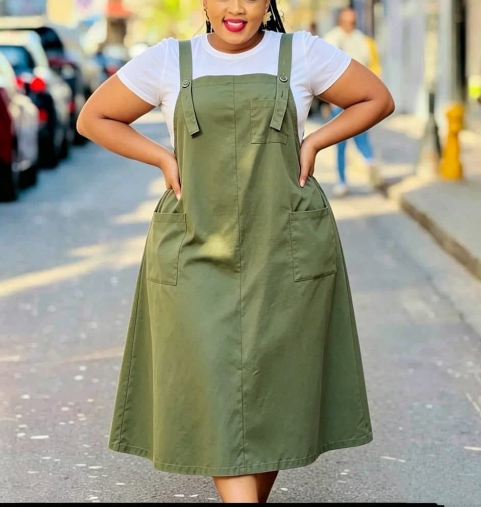 Woman wearing a utility pinafore midi dress with adjustable straps